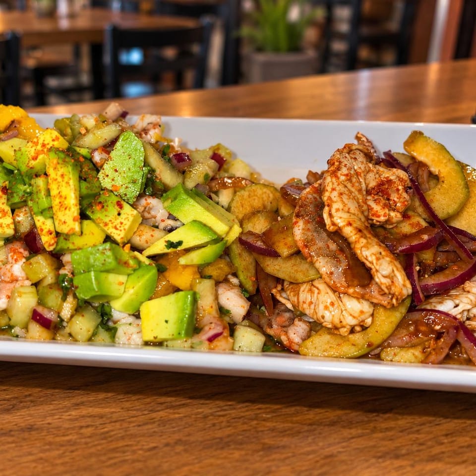 Seafood platter with avocado-topped ceviche and shrimp with cucumber and red onion.